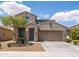 Charming two-story home featuring a well-manicured lawn, tree, and an attached two-car garage at 8924 N 102Nd Ln, Peoria, AZ 85345