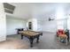 Large game room with pool table, dart board, and home theater setup on a neutral carpeted floor at 8924 N 102Nd Ln, Peoria, AZ 85345