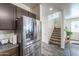 Kitchen features stainless steel refrigerator and a staircase leading to a naturally lit landing at 8924 N 102Nd Ln, Peoria, AZ 85345