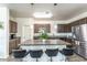 Modern kitchen with granite island countertop, stylish pendant lights, and stainless steel appliances at 8924 N 102Nd Ln, Peoria, AZ 85345