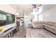 Spacious living room with wood-look tile flooring and a view of the kitchen at 8924 N 102Nd Ln, Peoria, AZ 85345