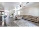 Bright living room featuring a cozy sectional sofa, area rug, ceiling fan, and staircase at 8924 N 102Nd Ln, Peoria, AZ 85345