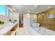 Spa-like bathroom featuring soaking tub, glass shower, vanity and ample natural light at 9669 E Chino Dr, Scottsdale, AZ 85255