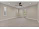 Neutral bedroom featuring plantation shutters, a ceiling fan, and backyard access at 9669 E Chino Dr, Scottsdale, AZ 85255