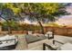Enjoy the cozy fire pit with comfortable seating, lush landscaping, and desert views for outdoor relaxation under mature trees at 9669 E Chino Dr, Scottsdale, AZ 85255