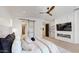 Spacious main bedroom with modern ceiling fan, barn door, and fireplace with television at 9669 E Chino Dr, Scottsdale, AZ 85255