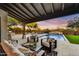 Relaxing covered patio with comfortable seating, outdoor dining, fire pit, and pool view to entertain Gathering and friends at 9669 E Chino Dr, Scottsdale, AZ 85255