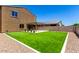 Spacious backyard with artificial grass, a covered patio, desert landscaping, and a privacy fence at 9837 E Satellite Dr, Mesa, AZ 85212
