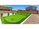 Turfed backyard with a putting green, a pergola, and rock landscaping at 9837 E Satellite Dr, Mesa, AZ 85212