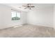 Bright carpeted bedroom featuring a ceiling fan and a view of the neighborhood at 9837 E Satellite Dr, Mesa, AZ 85212