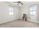 Bright bedroom with two windows, neutral carpet, and a decorative dollhouse display at 9837 E Satellite Dr, Mesa, AZ 85212