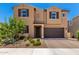 Two-story home featuring a desert landscape, tan stucco and a two car garage in a sunny neighborhood at 9837 E Satellite Dr, Mesa, AZ 85212
