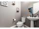 Modern powder room with round mirror, pedestal sink and neutral-toned walls at 9837 E Satellite Dr, Mesa, AZ 85212