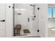 Walk-in shower features white tile, glass doors, and a built-in bench for added comfort at 9837 E Satellite Dr, Mesa, AZ 85212