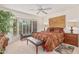 Bright main bedroom with large shuttered window, ceiling fan, and a cozy sitting area at 10626 N 8Th St, Phoenix, AZ 85020
