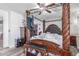 Bedroom featuring a decorative bedframe, bench, dresser, and organized storage space, with dark wood floors at 12128 W Range Mule Dr, Peoria, AZ 85383