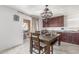 Inviting dining area with tile floors, wooden table, decorative lighting, and an open doorway to the exterior at 12128 W Range Mule Dr, Peoria, AZ 85383