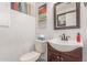 Cozy half bathroom with vanity, sink, toilet, decorative mirror and artwork, and a neutral color scheme at 12128 W Range Mule Dr, Peoria, AZ 85383