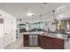Open-concept kitchen flows into living room, featuring granite counters, stainless steel appliances, and modern fixtures at 12128 W Range Mule Dr, Peoria, AZ 85383