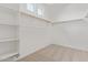 Spacious walk-in closet featuring carpeted floors, built-in shelving, and hanging rods at 12389 W Marguerite Ave, Avondale, AZ 85323