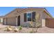 Close-up of the exterior with a three-car garage, desert landscaping and stylish window shutters at 12389 W Marguerite Ave, Avondale, AZ 85323