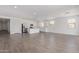 Bright, open-concept living space with wood-look tile and a seamless flow into the modern kitchen at 12389 W Marguerite Ave, Avondale, AZ 85323