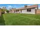 The backyard features lush green grass, a covered patio, and a well-maintained exterior at 1245 W Lobo Ave, Mesa, AZ 85202