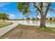 Scenic lake view with a paved walking path, surrounded by lush greenery and mature trees at 1245 W Lobo Ave, Mesa, AZ 85202