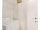 Bright laundry room featuring a white washing machine and a convenient storage shelf at 1245 W Lobo Ave, Mesa, AZ 85202