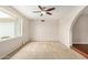 Bright living room with plush carpeting, a ceiling fan, and large windows with exterior views at 1245 W Lobo Ave, Mesa, AZ 85202
