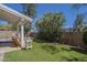 Relaxing backyard with artificial turf, covered patio, and mature trees at 1320 N Brittany Ln, Gilbert, AZ 85233