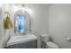 Stylish half-bathroom features modern vanity with sink, decorative mirror and updated toilet at 1320 N Brittany Ln, Gilbert, AZ 85233
