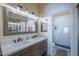 Stylish bathroom featuring a double vanity, framed mirrors, and a glass-enclosed shower at 1320 N Brittany Ln, Gilbert, AZ 85233