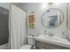 Cozy bathroom features a grey vanity, round mirror, and a shower with a curtain at 1320 N Brittany Ln, Gilbert, AZ 85233