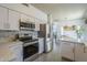 Spacious kitchen featuring stainless appliances, white cabinets, tile floors, and an open view to dining at 1320 N Brittany Ln, Gilbert, AZ 85233