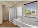 Bathroom features a shower, bathtub, and large window with natural light at 13722 N 150Th Ln, Surprise, AZ 85379