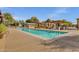 Expansive community pool featuring a lap lane, sun loungers, and covered seating areas at 13722 N 150Th Ln, Surprise, AZ 85379