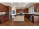 Well-equipped kitchen with stainless steel appliances, island with granite countertops, and dark wood cabinetry at 13722 N 150Th Ln, Surprise, AZ 85379