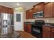 Functional kitchen with stainless steel appliances, granite countertops, dark wood cabinetry and stainless refrigerator at 13722 N 150Th Ln, Surprise, AZ 85379