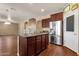 Open kitchen with a large center island, stainless steel refrigerator, wood floors and access to the dining area at 13722 N 150Th Ln, Surprise, AZ 85379