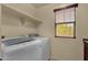 Practical laundry room with modern washer and dryer and convenient overhead shelving at 13722 N 150Th Ln, Surprise, AZ 85379