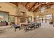 Inviting lounge area with stone fireplace and views of the pool area beyond the fence at 13722 N 150Th Ln, Surprise, AZ 85379