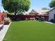 Spacious backyard with artificial turf, brick walls, seating, and landscaping at 14211 N 149Th Dr, Surprise, AZ 85379