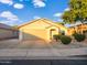 Charming single-story home featuring a well-manicured front yard with lush landscaping and a two-car garage at 14211 N 149Th Dr, Surprise, AZ 85379