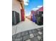 Narrow side yard with access to the backyard between house and brick fence under a sunny, blue sky at 14211 N 149Th Dr, Surprise, AZ 85379