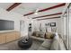 A virtually staged living room area featuring exposed beams and access to the kitchen and dining area at 1515 N Saguaro Dr, Tempe, AZ 85288