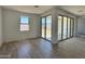 Airy room with sliding glass doors opening to outdoor space, featuring tile floors and a bright atmosphere at 15785 W Beryl Ave, Waddell, AZ 85355