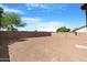 Large private backyard features dirt surface and a sturdy brick wall, perfect for landscaping and activities at 1623 E Leaf Rd, San Tan Valley, AZ 85140
