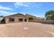 View of a large, gravel backyard featuring block wall fencing and a sliding glass door to the home at 1623 E Leaf Rd, San Tan Valley, AZ 85140