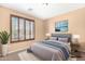 Cozy bedroom showcases a neutral palette, plush carpeting, and a large window for ample natural light at 1623 E Leaf Rd, San Tan Valley, AZ 85140